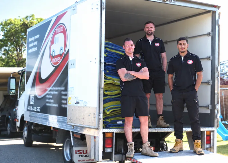 Micro Moves team at the rear of their equipped moving truck